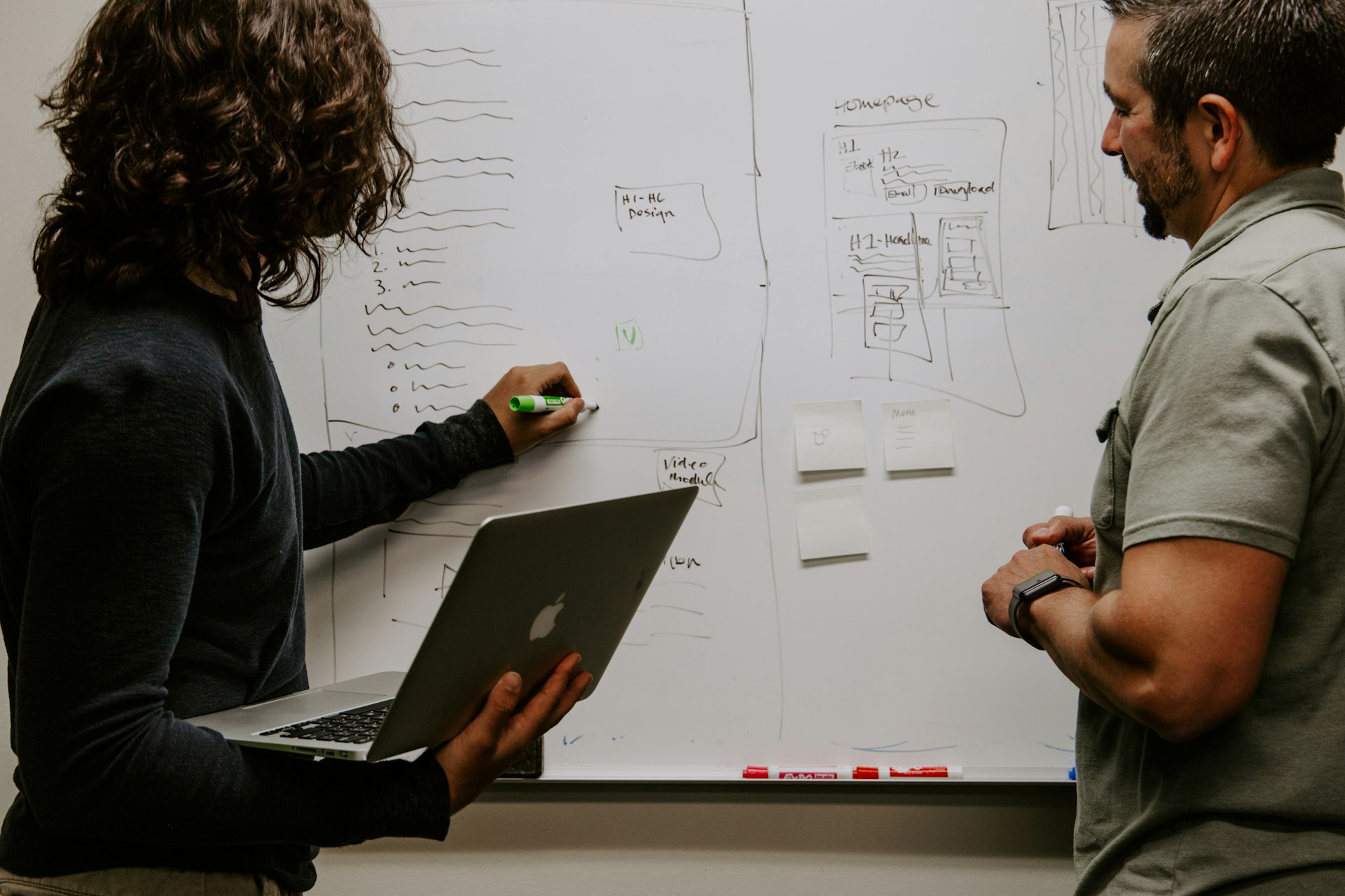 Une organisation communautaire Photo : Deux personnages travaillant ensemble sur un tableau blanc